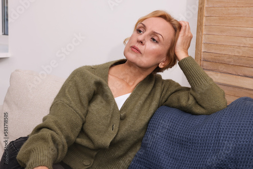 Foto Upset middle aged woman sulking on sofa at home