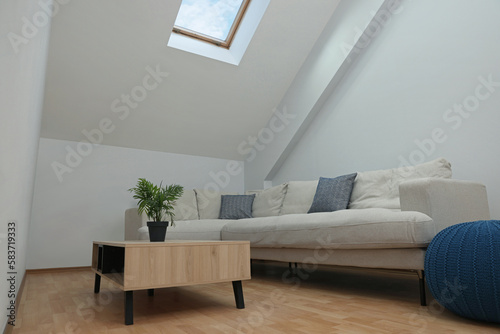 Attic room interior with slanted ceiling and furniture