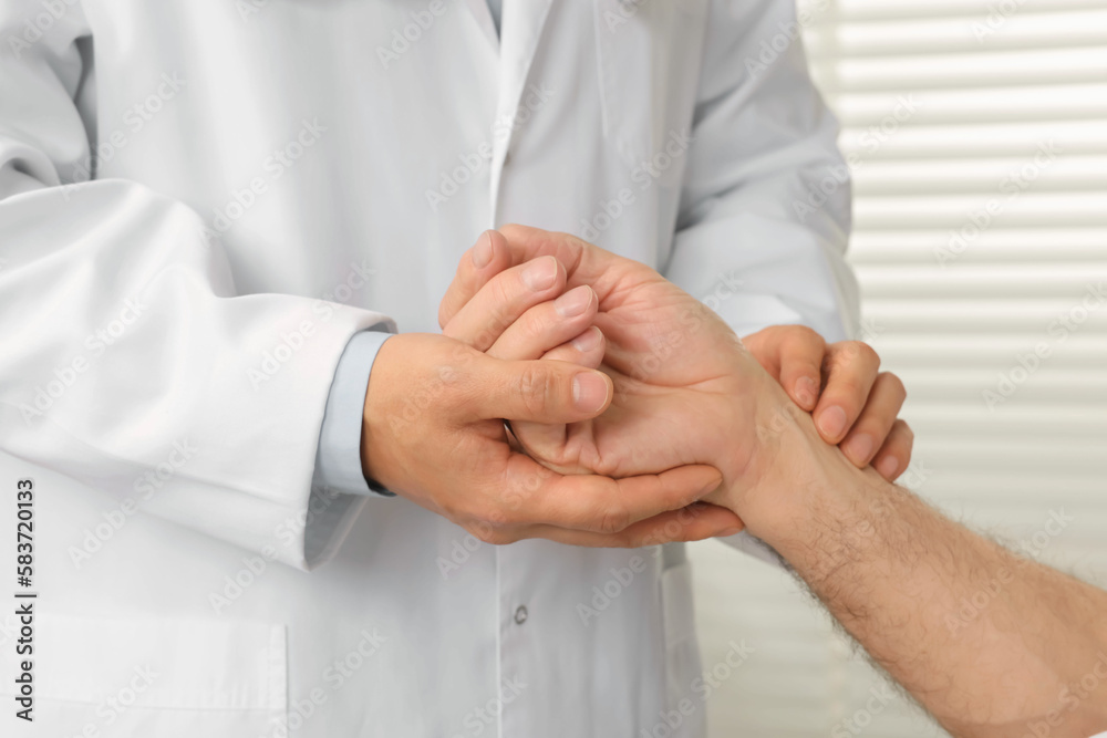 Doctor checking senior man`s pulse in hospital, closeup Doctor checking senior man`s pulse in hospital, closeup
