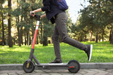 Man riding modern electric scooter in park, closeup