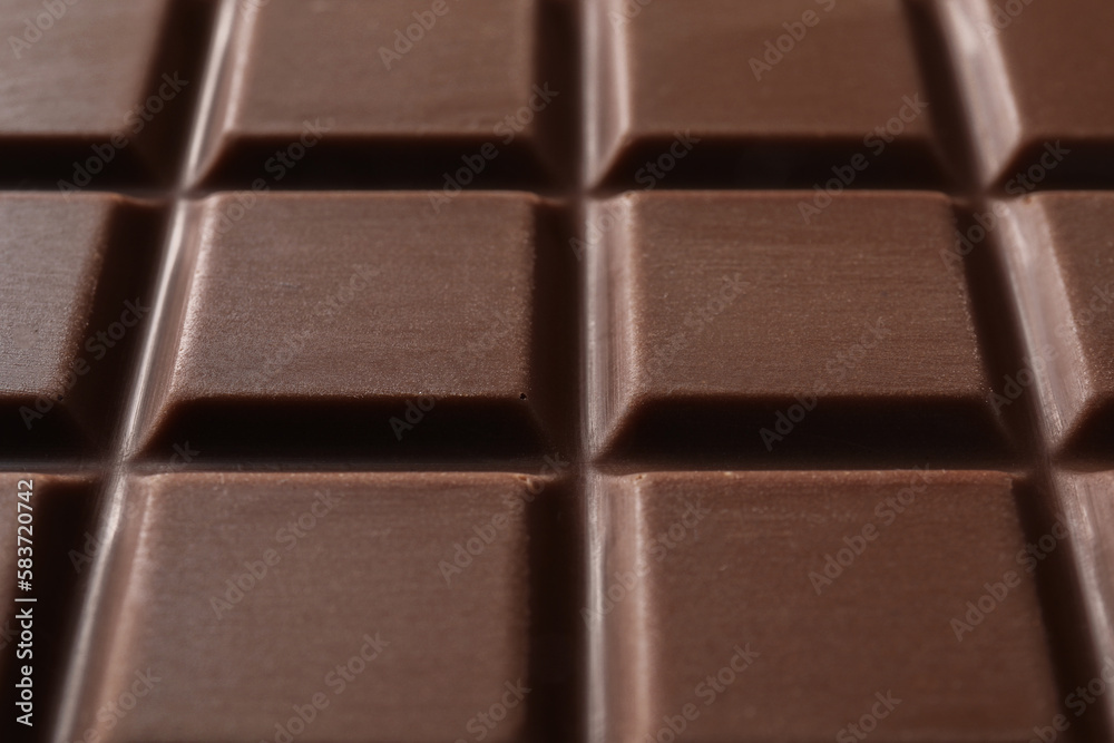 Delicious milk chocolate bar as background, closeup Delicious milk chocolate bar as background, closeup