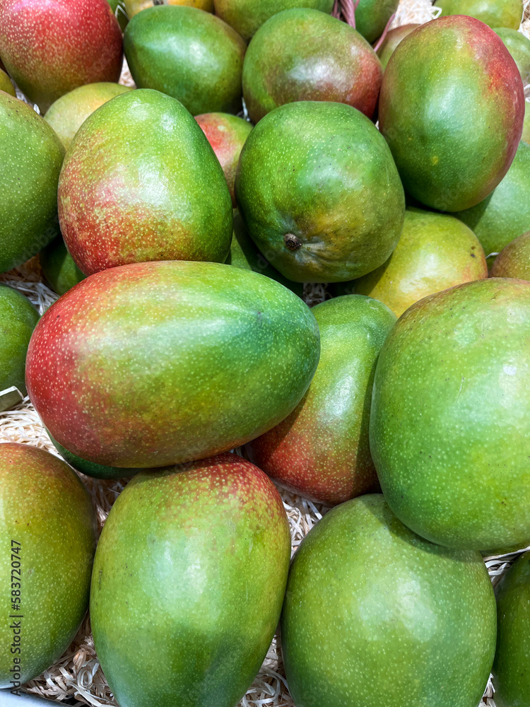 A wide selection of delicious, ripe mangoes available at the farmer's market A wide selection of delicious, ripe mangoes available at the farmer's market