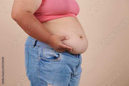 she wants to lose weight concept of abdominal fat surgery., the girl takes extra fat on sides of her stomach with her hand. isolate on white background, Type with increased fat deposition and fullness