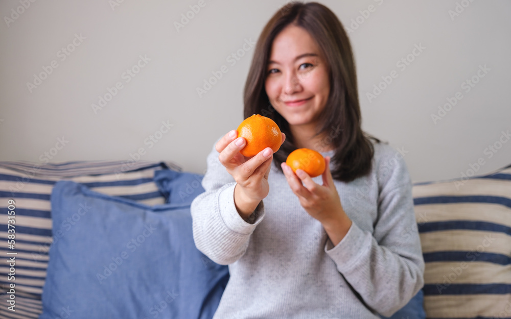 Portrait image of a young woman holding oranges in hands Portrait image of a young woman holding oranges in hands