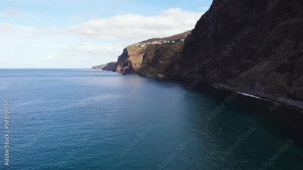 Aerial reveal of steep rocky volcanic coast in Madeira on ocean shoreline Aerial reveal of steep rocky volcanic coast in Madeira on ocean shoreline