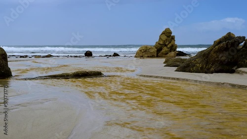 Onrus lagoon water with tannins flow over beach into ocean, Overstrand photo