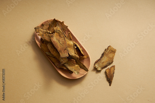 Angel view of rhizoma rhei put on wooden dishes on light brown background. Chinese herbal medicine with laxative effect and diarrhea control