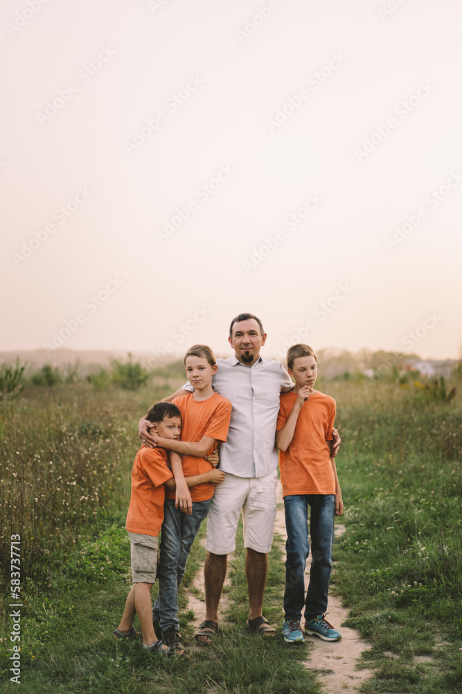 Happy Fathers day. Father with son are walking in the field. Dad hugs boy. The concept of Fathers day, relationships with children, care and love. Happy Fathers day. Father with son are walking in the field. Dad hugs boy. The concept of Fathers day, relationships with children, care and love.