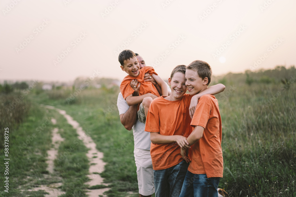 Happy Fathers day. Father with son are walking in the field. Dad hugs boy. The concept of Fathers day, relationships with children, care and love. Happy Fathers day. Father with son are walking in the field. Dad hugs boy. The concept of Fathers day, relationships with children, care and love.