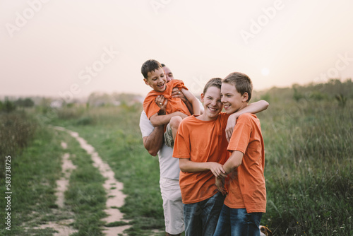 Happy Fathers day. Father with son are walking in the field. Dad hugs boy. The concept of Fathers day, relationships with children, care and love.