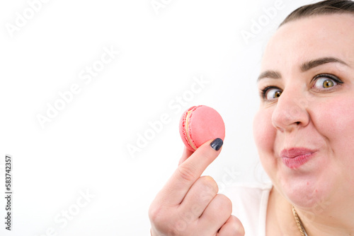 Cheerful beautiful girl eating macaroon with eyes closed isolated over white background. High quality photo photo