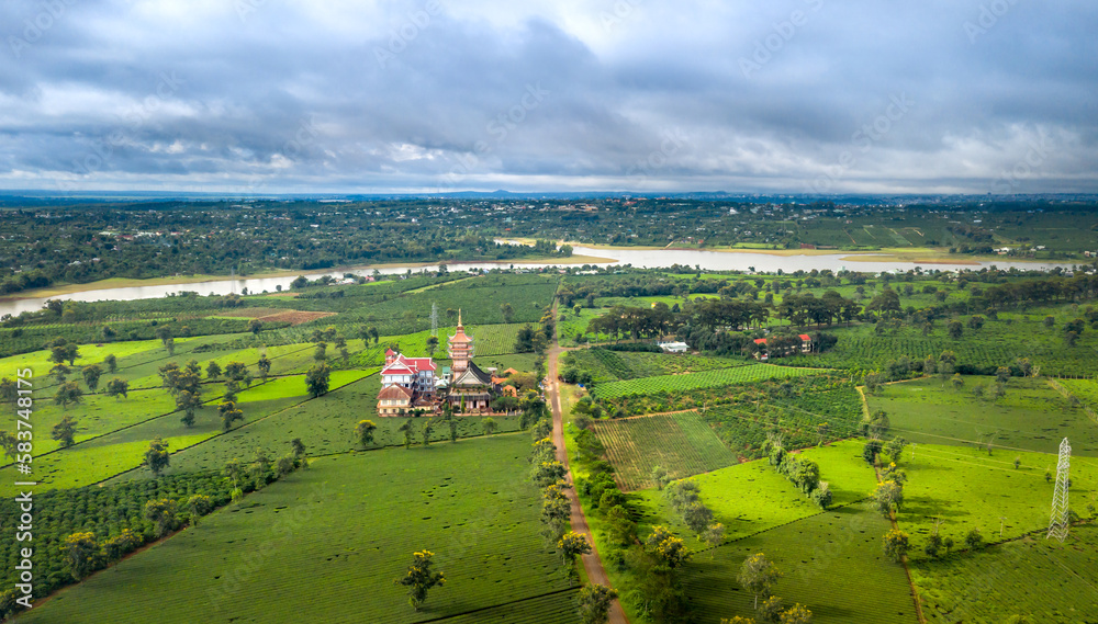 Naklejka premium Aerial view of an ancient pagoda in the middle of a green tea field in Pleiku town, Gia Lai province, Vietnam