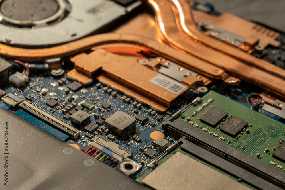A technician repairs a broken laptop computer with a screwdriver. Notebook components and parts close-up A technician repairs a broken laptop computer with a screwdriver. Notebook components and parts close-up