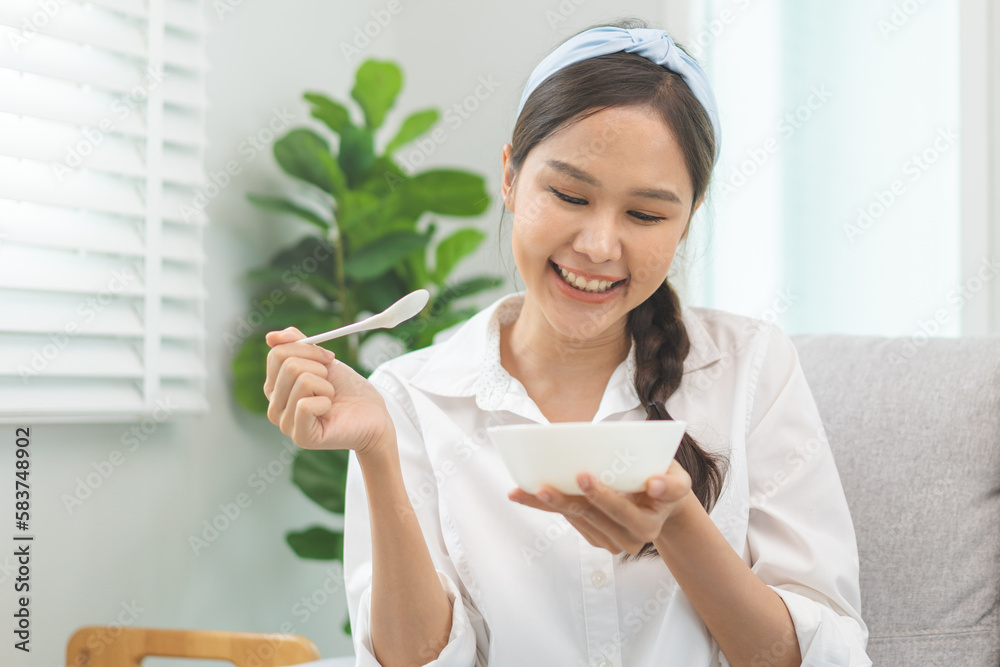 Healthy lifestyle, wellness food asian young woman hand use spoon eat tasty fresh organic yogurt, dairy product in bowl breakfast meal at home. Snack tasty on diet nutrition delicious natural yoghurt Healthy lifestyle, wellness food asian young woman hand use spoon eat tasty fresh organic yogurt, dairy product in bowl breakfast meal at home. Snack tasty on diet nutrition delicious natural yoghurt