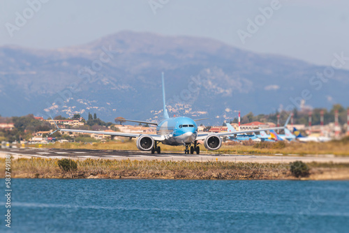 View of modern passenger plane aircraft on an runway airfield ready to take off, airstrip with commercial airplane before take off or after landing, airliner with mountains in a summer day © tsuguliev