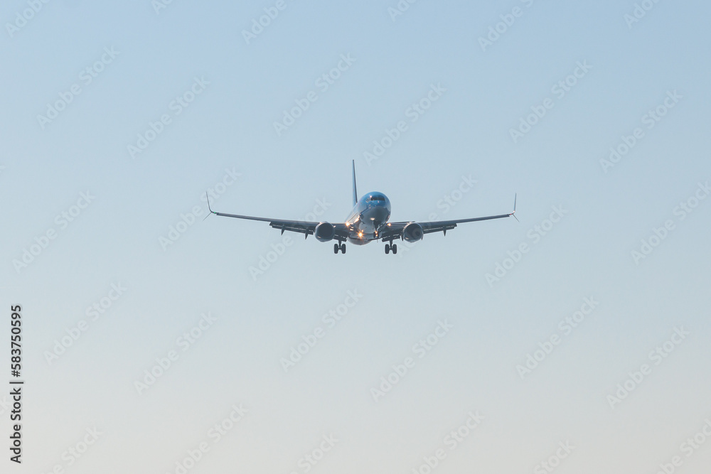 View of modern passenger plane aircraft in flight, commercial airplane flying in the sky before take off or landing, with mountains in the background in a summer sunny day View of modern passenger plane aircraft in flight, commercial airplane flying in the sky before take off or landing, with mountains in the background in a summer sunny day