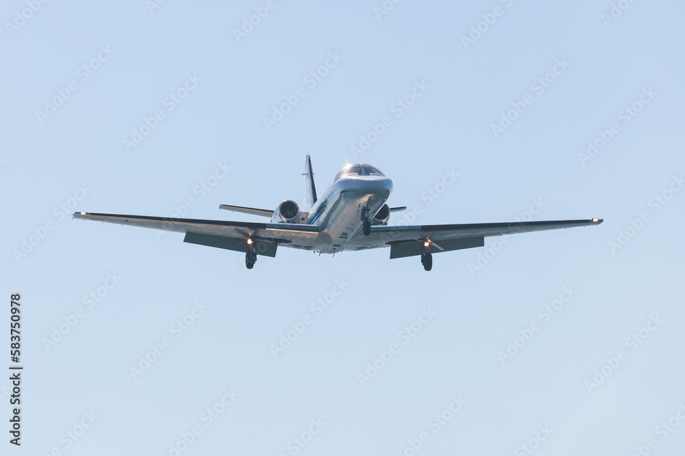 View of modern private reactive plane aircraft in flight, business airliner jet airplane before in the air with mountains in the background in a summer sunny day, corporate jet view