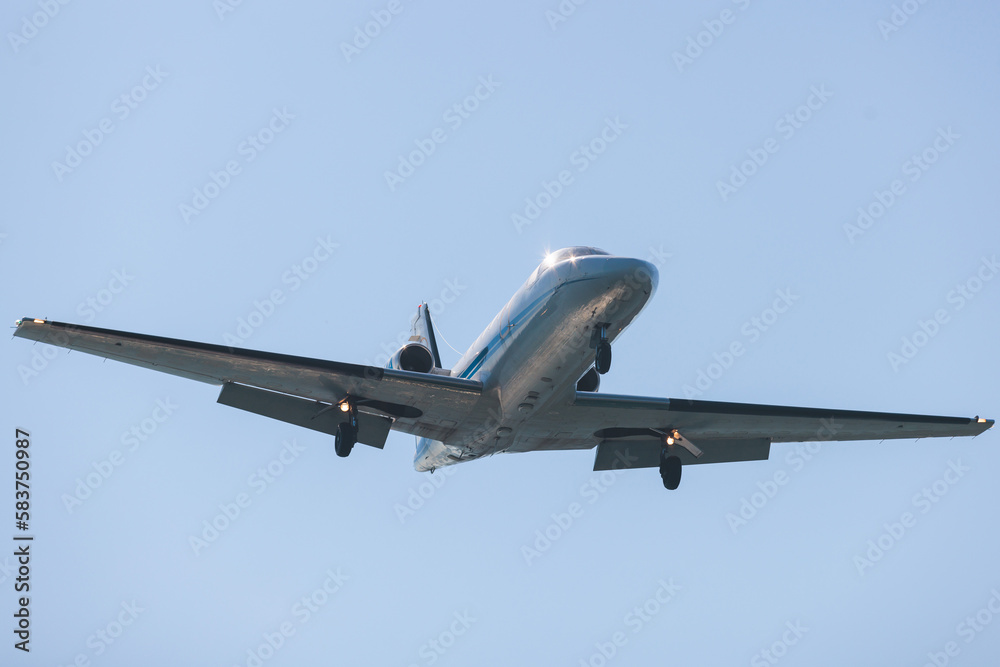 View of modern private reactive plane aircraft in flight, business airliner jet airplane before in the air with mountains in the background in a summer sunny day, corporate jet view
