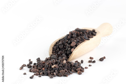 Himalayan black salt in a wooden spoon on a white background. Copy space.