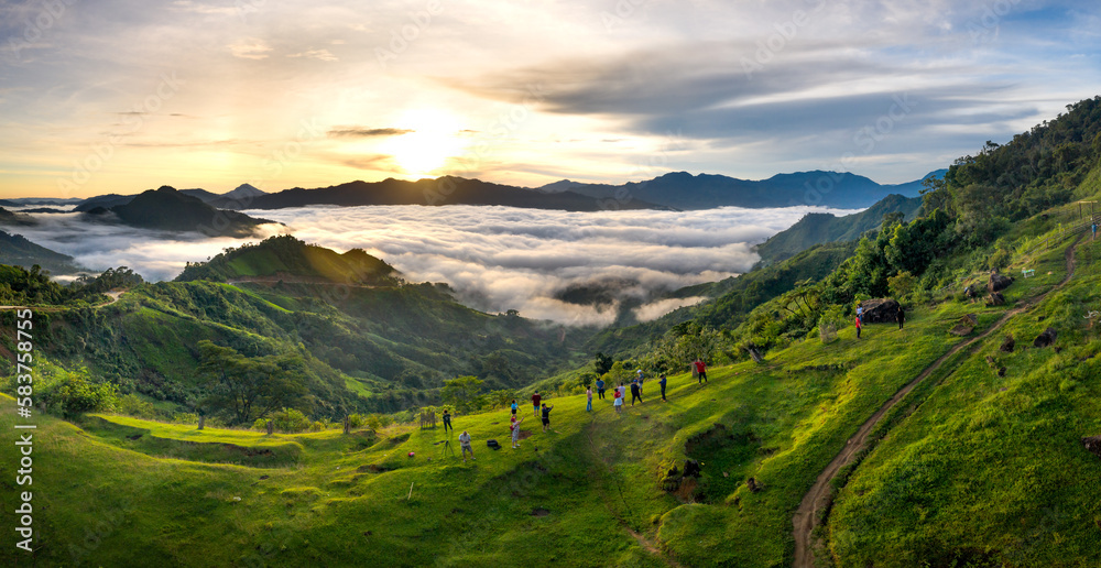 Panoramic view of sunrise with a trail going through a valley filled with white clouds in the Tak Po mountains in Tra Tap commune, Nam Tra My district, Quang Nam province, Vietnam