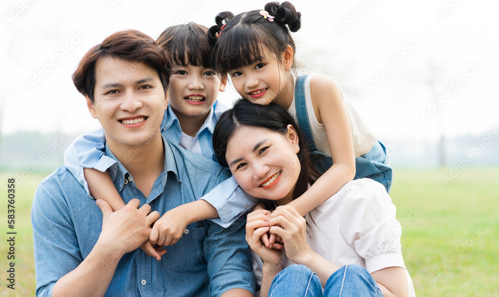 image of an asian family sitting together on the grass at the park image of an asian family sitting together on the grass at the park