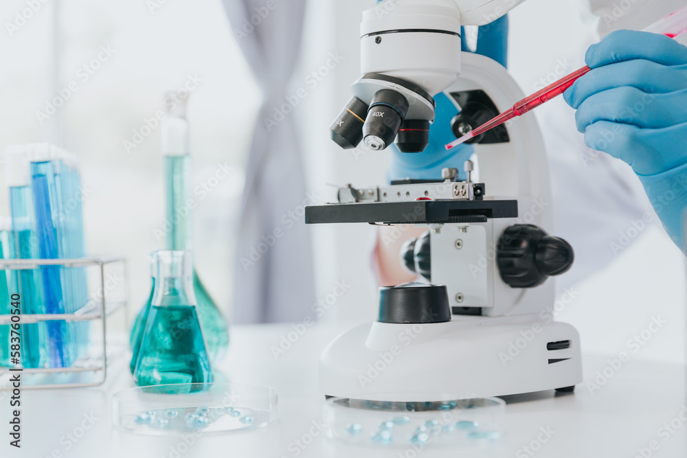 Scientist or doctor wear medical protective mask looking at blood samples under microscope. Scientist or doctor wear medical protective mask looking at blood samples under microscope.