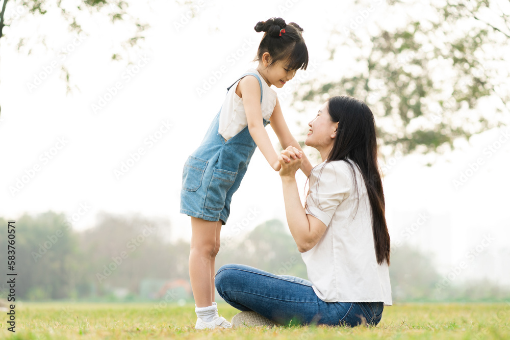 image of mother and daughter playing in the park image of mother and daughter playing in the park