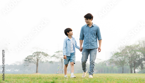 image of an asian father and son having fun in the park