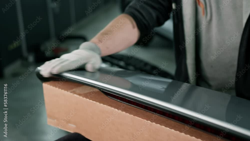 Gluing the film on the spoiler to protect the paint which protects the