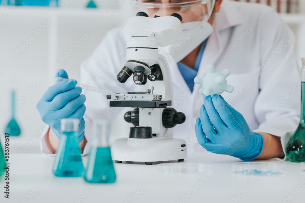 Young scientist looking through a microscope in a laboratory. Young scientist doing some research.