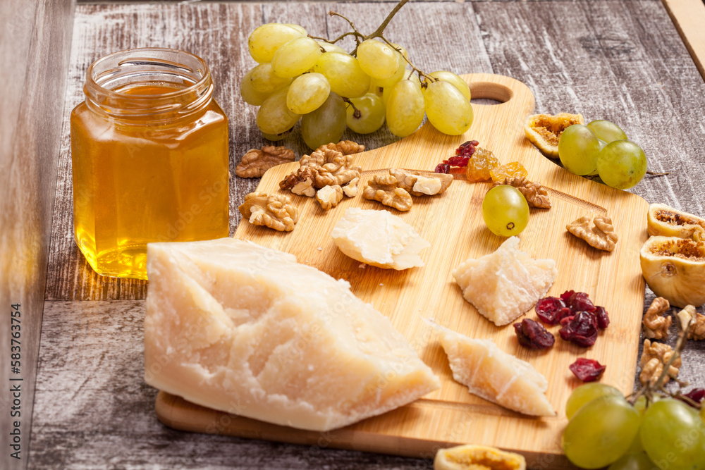 Cheese, honey and grape on wooden background in studio photo Cheese, honey and grape on wooden background in studio photo