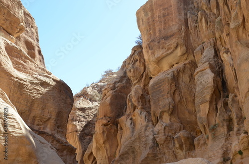 Beautiful rocks and canyons in the wild nature and the dry desert of Wadi Ghweir in Jordan on a bright sunny day