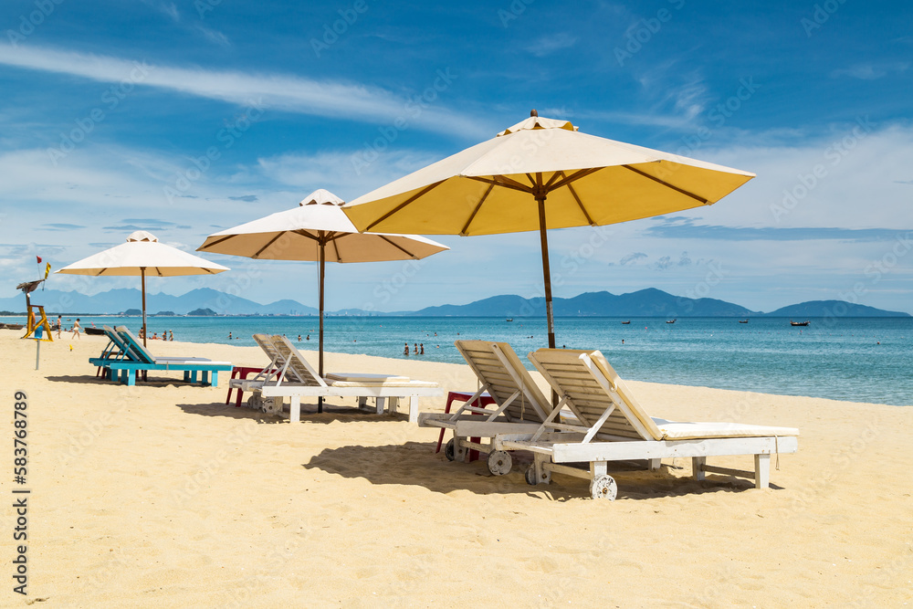 Lounge chairs and umbrellas on a white sandy beach at An Bang in Vietnam