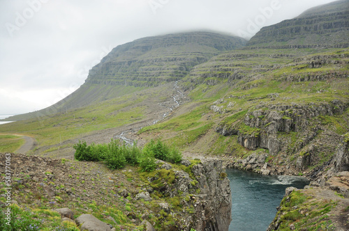 Scenic view of a river flowing between grass cliffs in Iceland