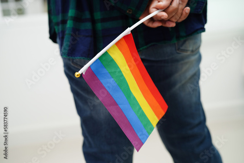Asian woman with rainbow flag, LGBT symbol rights and gender equality, LGBT Pride Month in June.