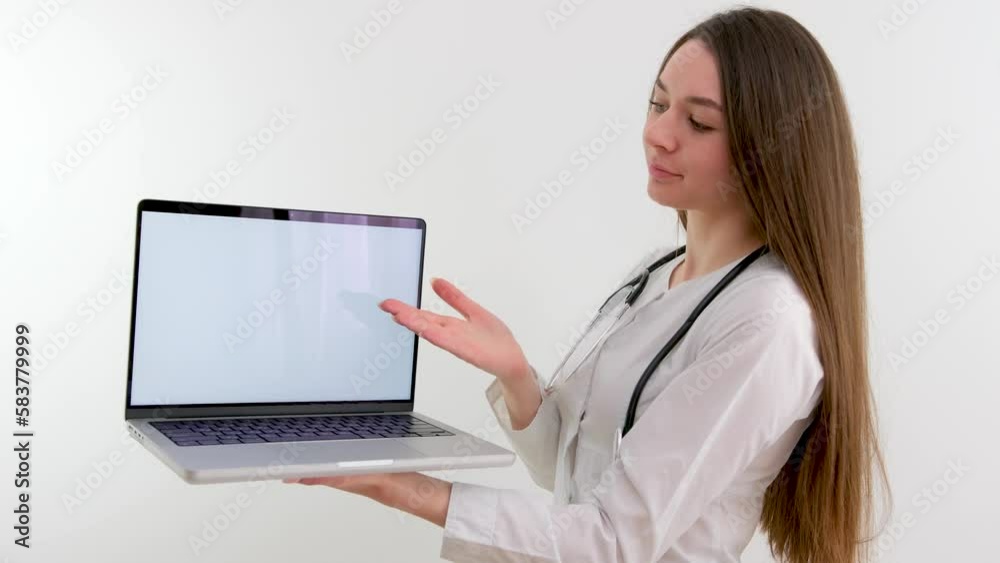 beautiful young doctor nurse holding laptop with a white screen in her hands advertising a new remedy treatment food supplements presenting in team meeting with using tablet for explaining beautiful young doctor nurse holding laptop with a white screen in her hands advertising a new remedy treatment food supplements presenting in team meeting with using tablet for explaining
