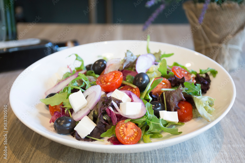 Delicious and healthy salad with cheese and a variety of vegetables and tomatoes.