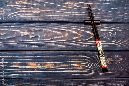 Chopsticks for sushi lie on a brown wooden background 