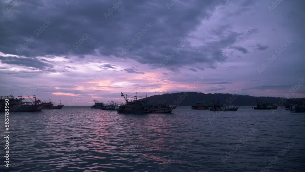Silhoutted Fishing Trawlers moored at Kota Kinabalu Harbour at Majestic Colorful Sunset Reflected in Sea Water Silhoutted Fishing Trawlers moored at Kota Kinabalu Harbour at Majestic Colorful Sunset Reflected in Sea Water