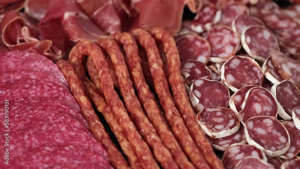 Meat plate with assortment of various tasty Spanish, french or Italian appetizers - sliced prosciutto, sausage, salami, kabanos sausages, fuet. Meat platter rotating Meat plate with assortment of various tasty Spanish, french or Italian appetizers - sliced prosciutto, sausage, salami, kabanos sausages, fuet. Meat platter rotating