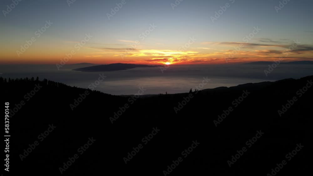 El Teide Volcano landscape in silhouette at sunset with Port Cruz below, Tenerife Canary islands Spain, Aerial flyover shot El Teide Volcano landscape in silhouette at sunset with Port Cruz below, Tenerife Canary islands Spain, Aerial flyover shot