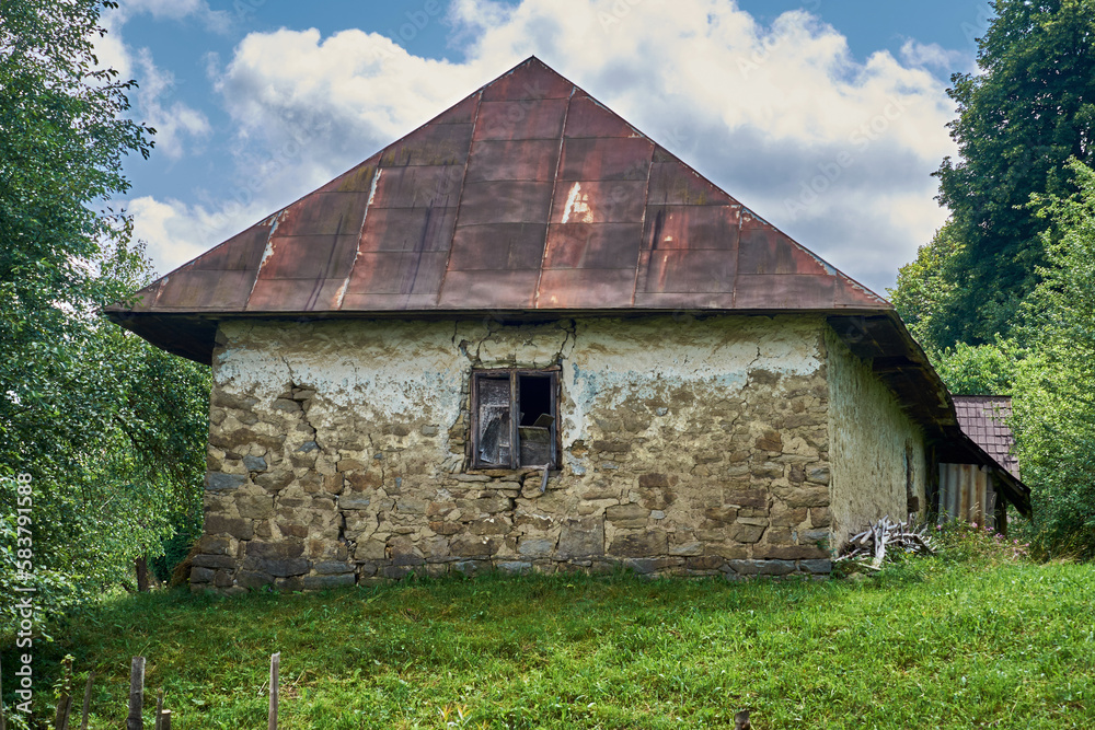 Obraz premium Old cracked house made of stones and clay. Abandoned house in the mountain village of Transcarpathian Ukraine