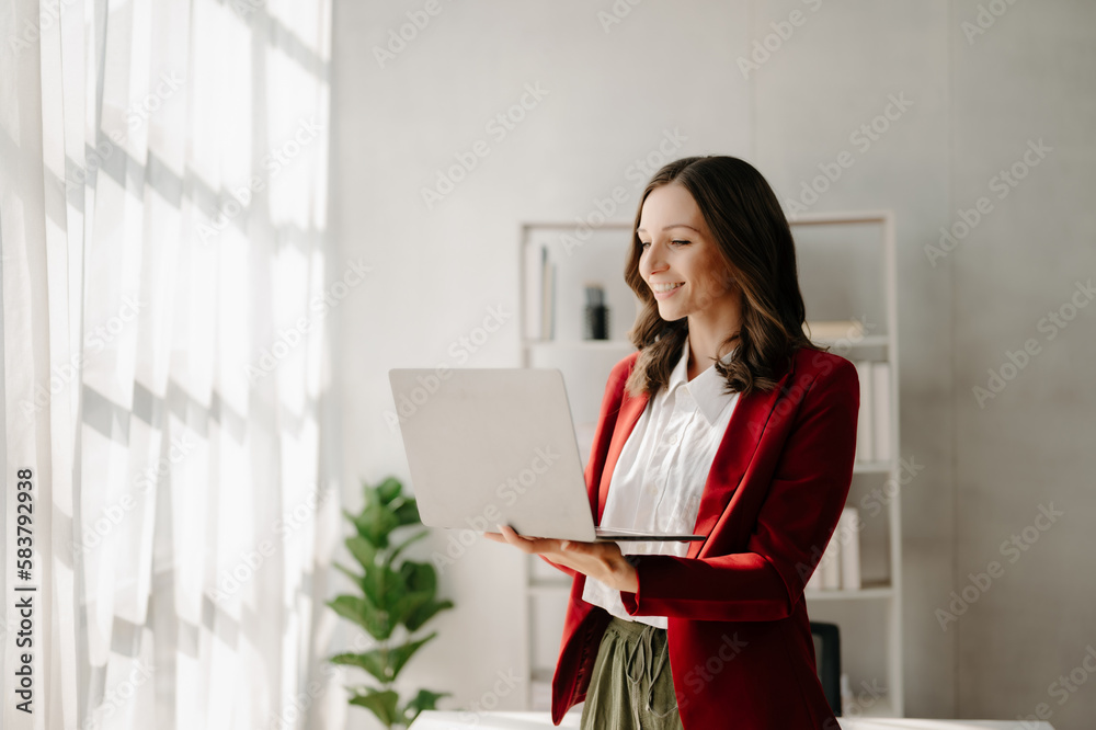 Young attractive Asian female office worker business suits smiling at camera in home office Young attractive Asian female office worker business suits smiling at camera in home office