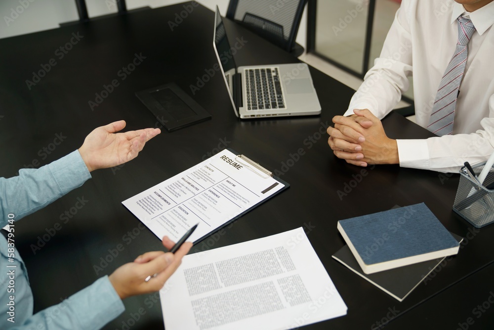 Examiner reading a resume during job interview at office Business and human resources concept. Examiner reading a resume during job interview at office Business and human resources concept.