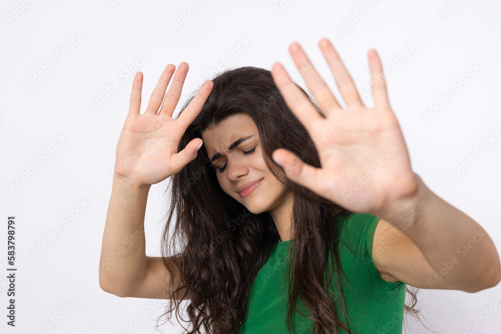 Portrait of a serious young woman showing stop gesture with her palm over white background Portrait of a serious young woman showing stop gesture with her palm over white background