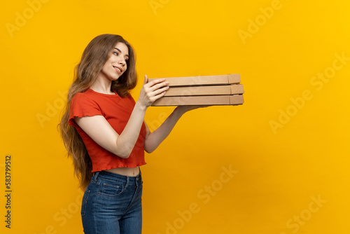 Fotomurale A female pizza courier appears in this photo, framed by a bold yellow backdrop a