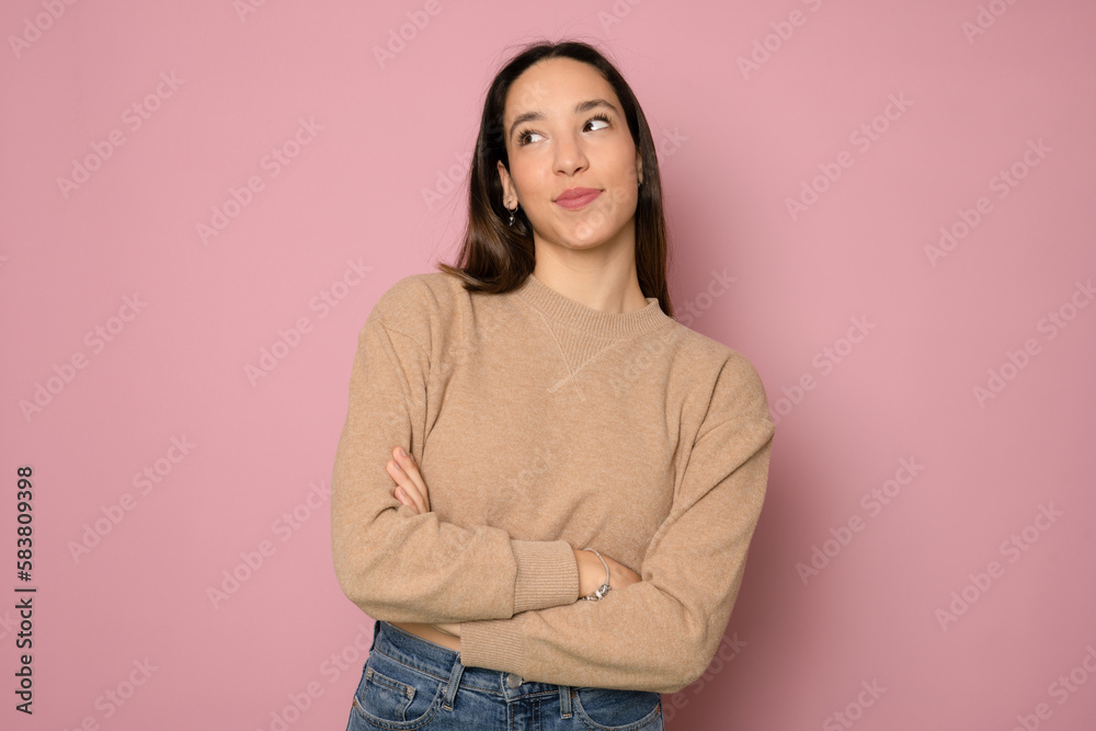 Portrait of a happy woman standing with arms folded isolated on a pink background Portrait of a happy woman standing with arms folded isolated on a pink background