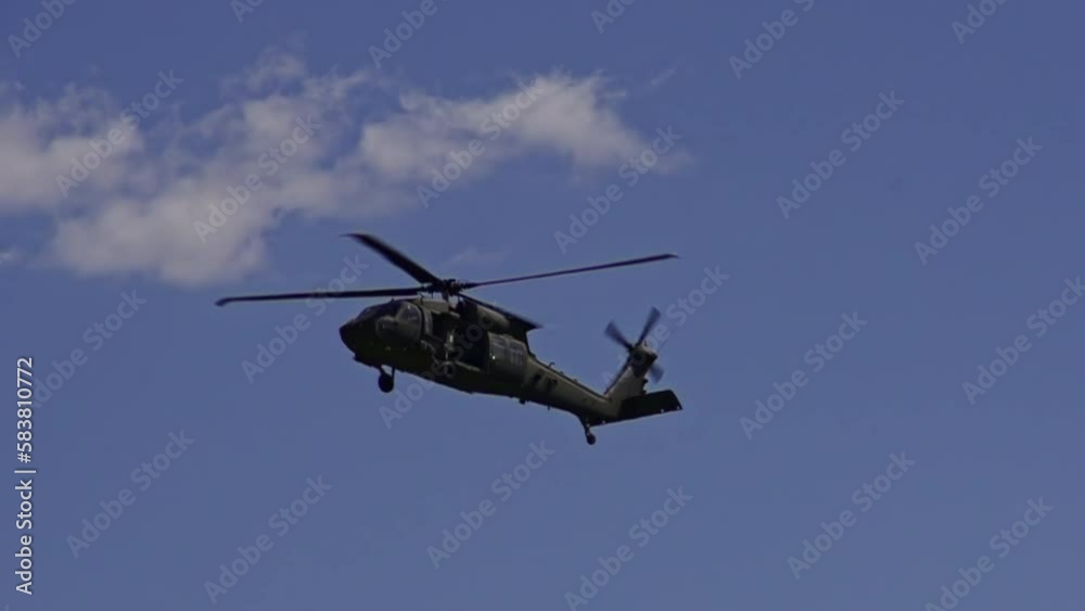 Slow motion shot of flying Cargo helicopter flying at blue sky, bottom up Slow motion shot of flying Cargo helicopter flying at blue sky, bottom up