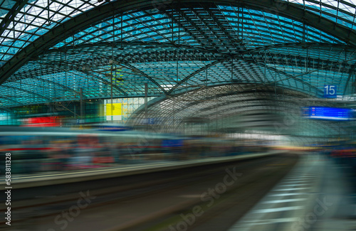 Abstract geometry of the metal and glass ceilings, poles, and railway tracks in Berlin Train Station in Germany