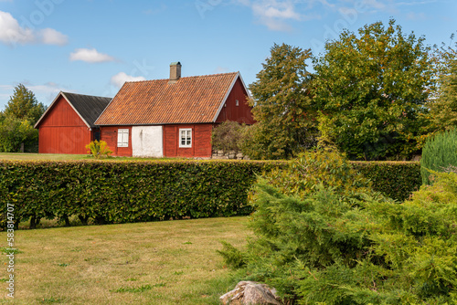Old red wooden house in vintage Scandinavian style. Traditional ancient Sweden house in the village. 